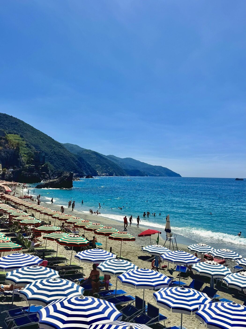 The beach lined with blue and white striped umbrellas