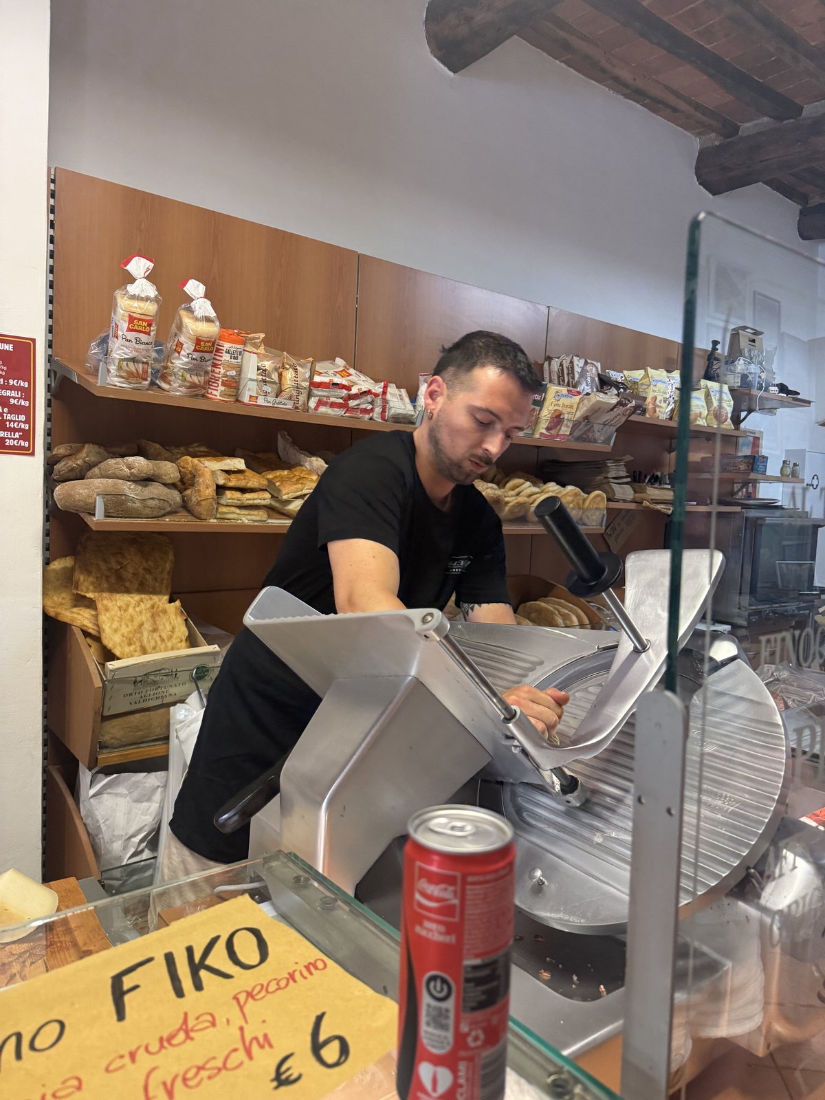 Ricardo slicing meat behind the counter at the Del Moro sandwich shop