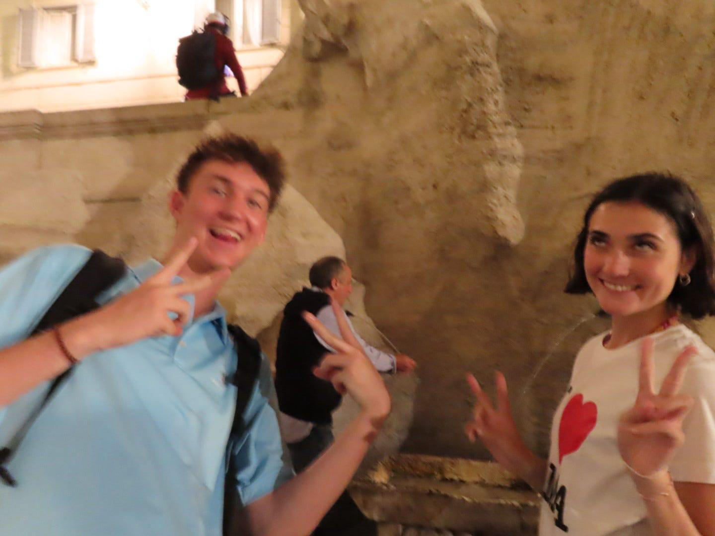 Seth and me throwing peace signs by the fountain at night