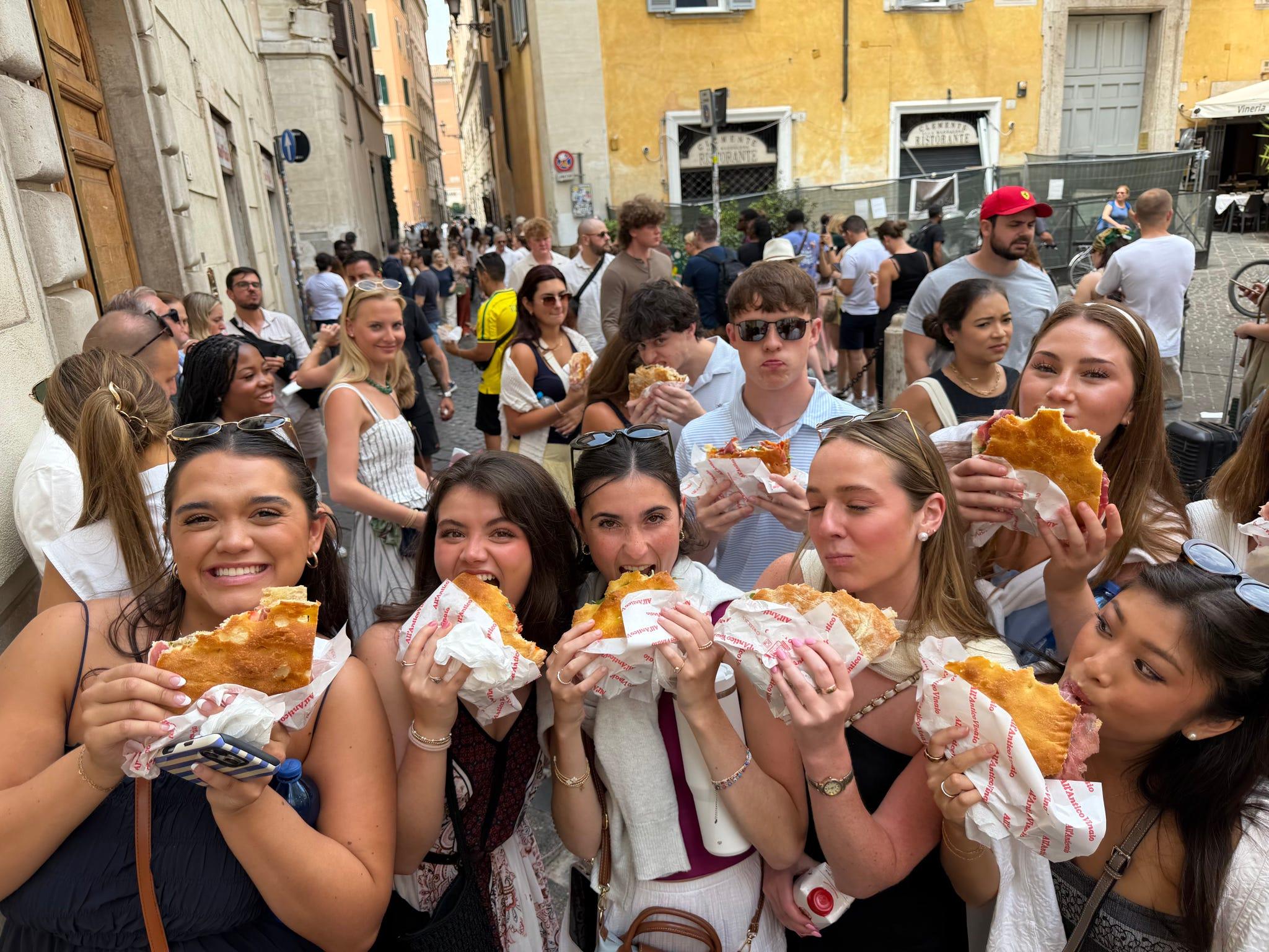 The whole group holding up sandwiches from All&rsquo;Antico Vinaio