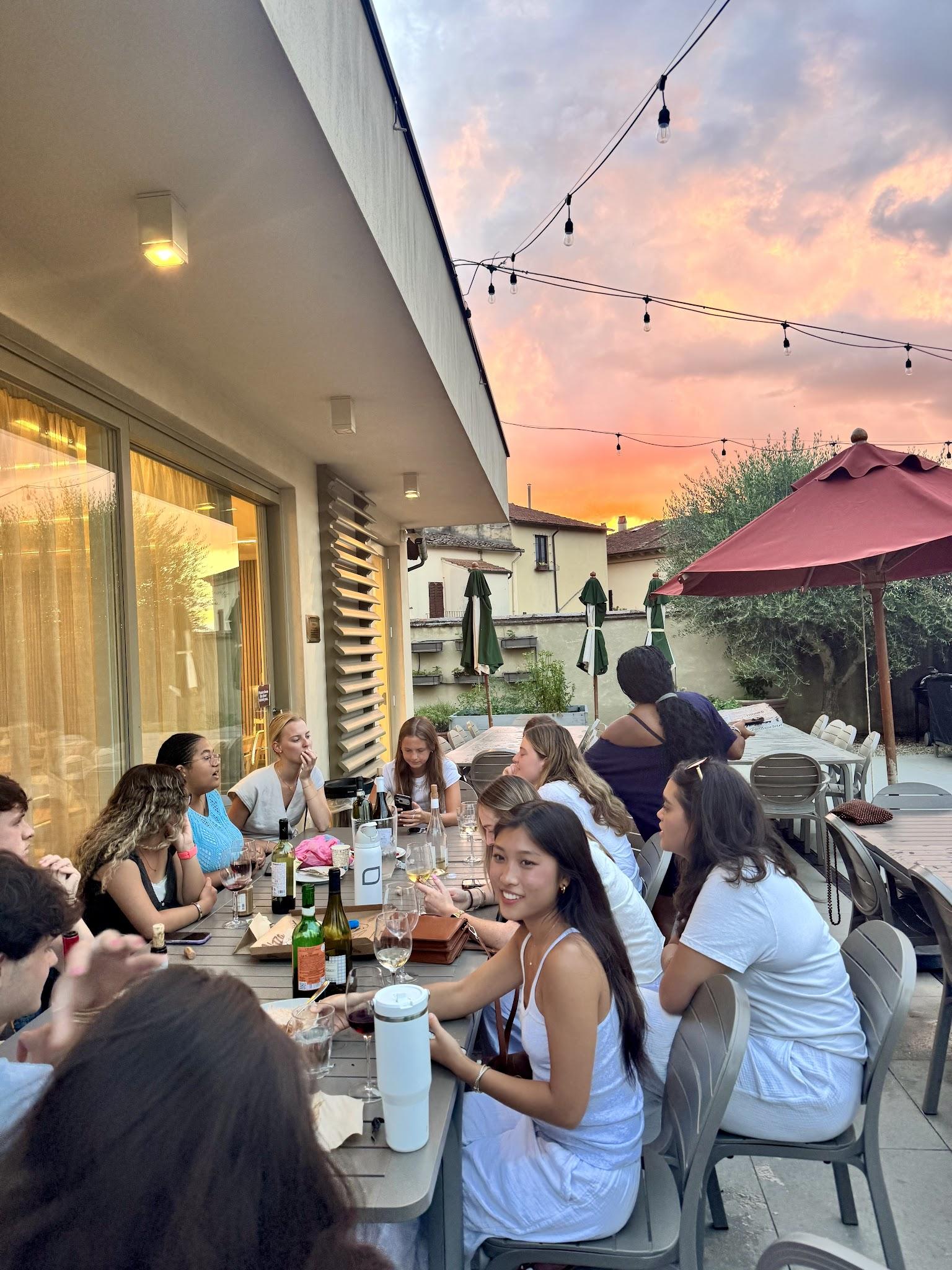 The group gathered around a long table in the dorm garden at sunset