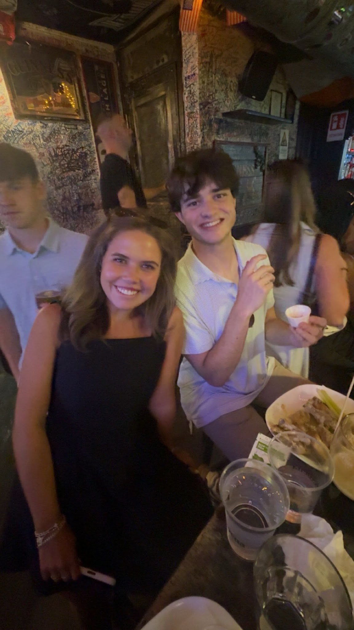 Smiling at a table at Lions Fountain with food and drinks